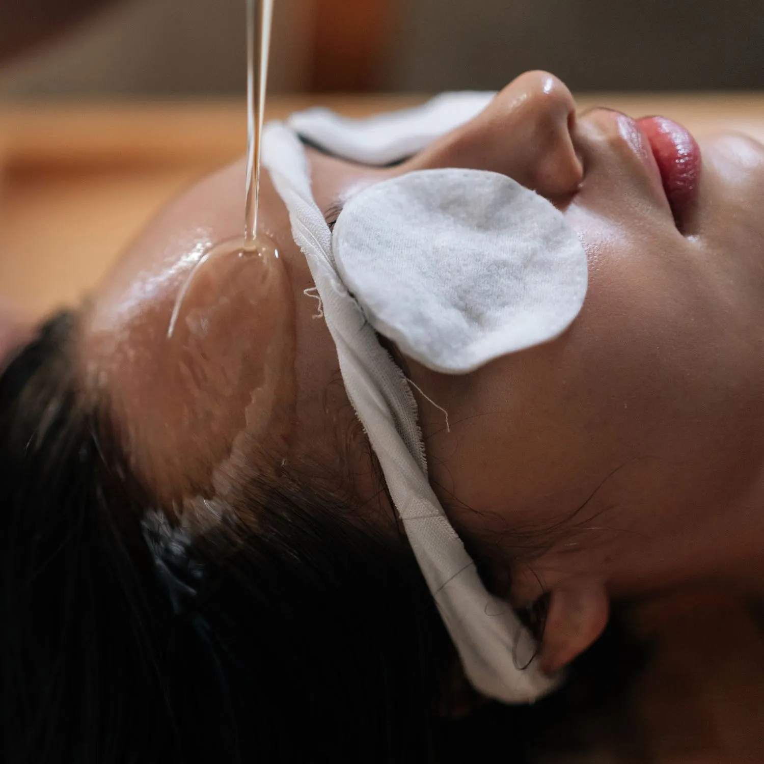 Ayurvedic shirodhara treatment at retreat inn kerala ayurveda yoga resort Close-up of a woman receiving Shirodhara therapy, with warm herbal oil gently streaming onto her forehead during an Ayurvedic treatment session at retreat inn kerala ayurveda yoga resort.