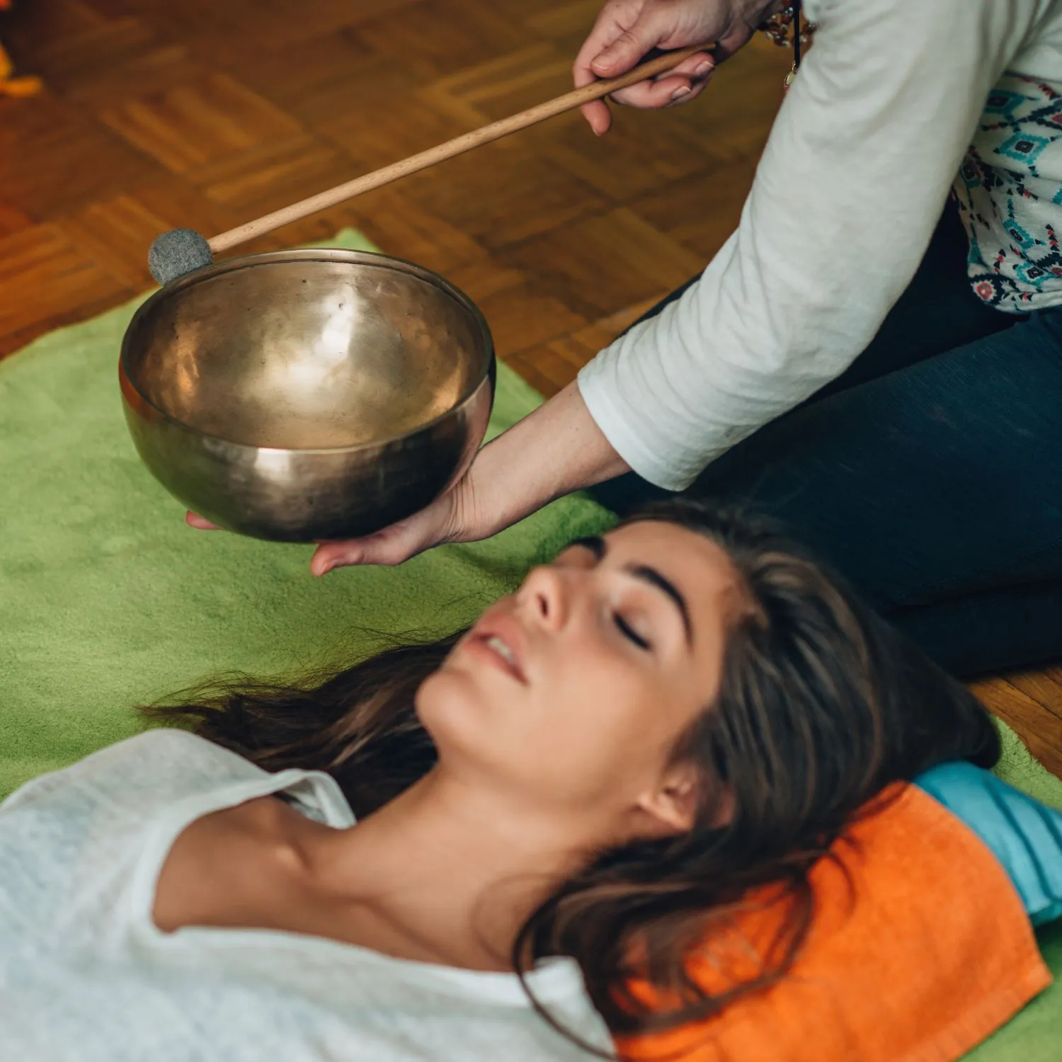 Sound Healing Therapy at Retreat Inn Kerala – An Authentic Ayurveda Yoga Retreat Experience Woman receiving a sound healing session with a Tibetan singing bowl during a wellness therapy at Retreat Inn Kerala Ayurveda Yoga Resort — a serene Ayurveda yoga retreat.